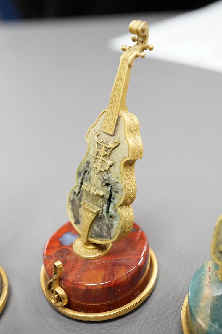 A set of four mid 20th century Italian 800 standard gilt white metal miniature model string instruments, including a lyre and lute, each mounted on a circular hardstone base, including jasper and adventurine quartz, 65mm